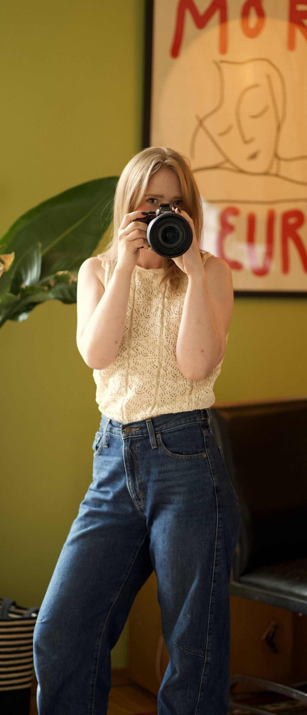 Calgary family photographer Anna standing near a wooden sideboard