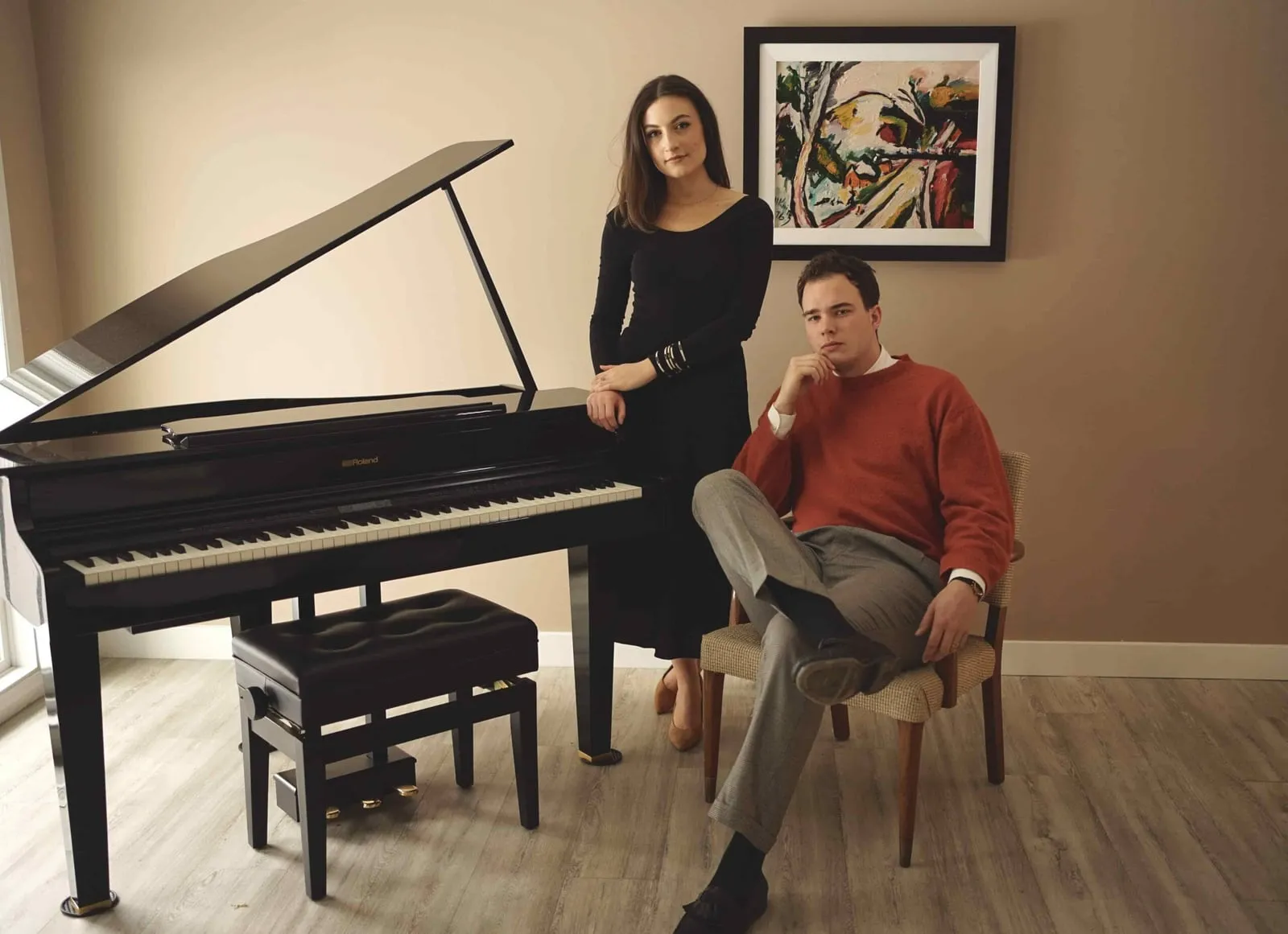 Couple posed beside a grand piano in an elegant room