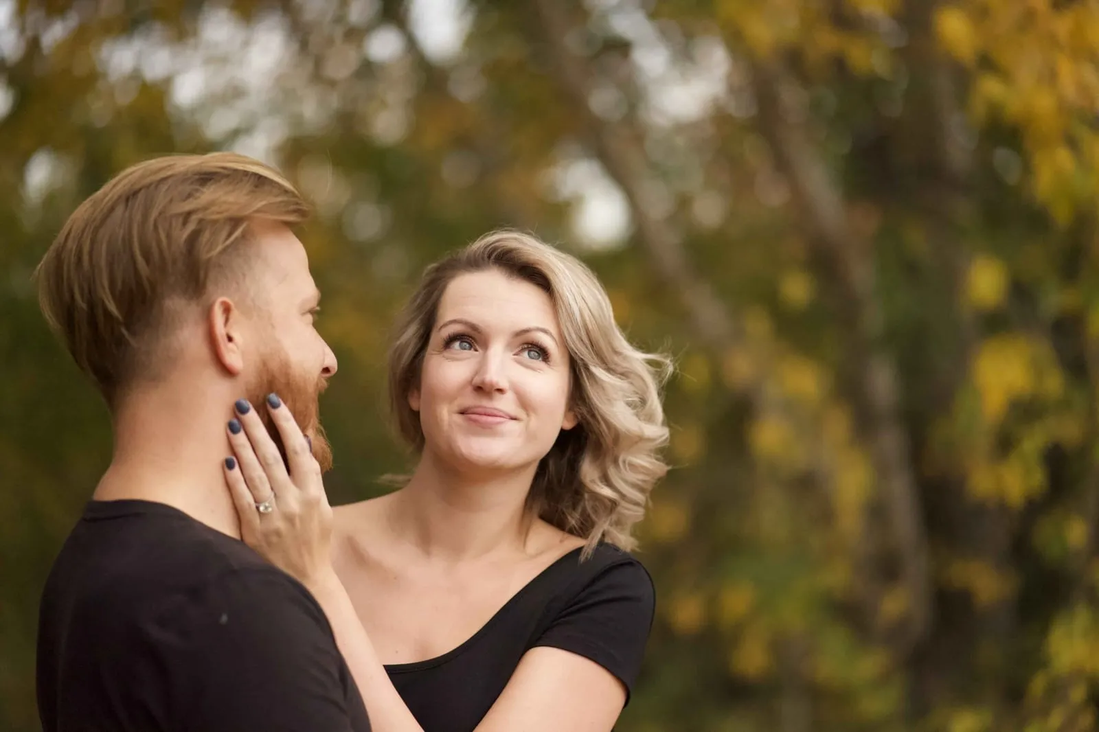 Woman touching her partner's face among autumn trees